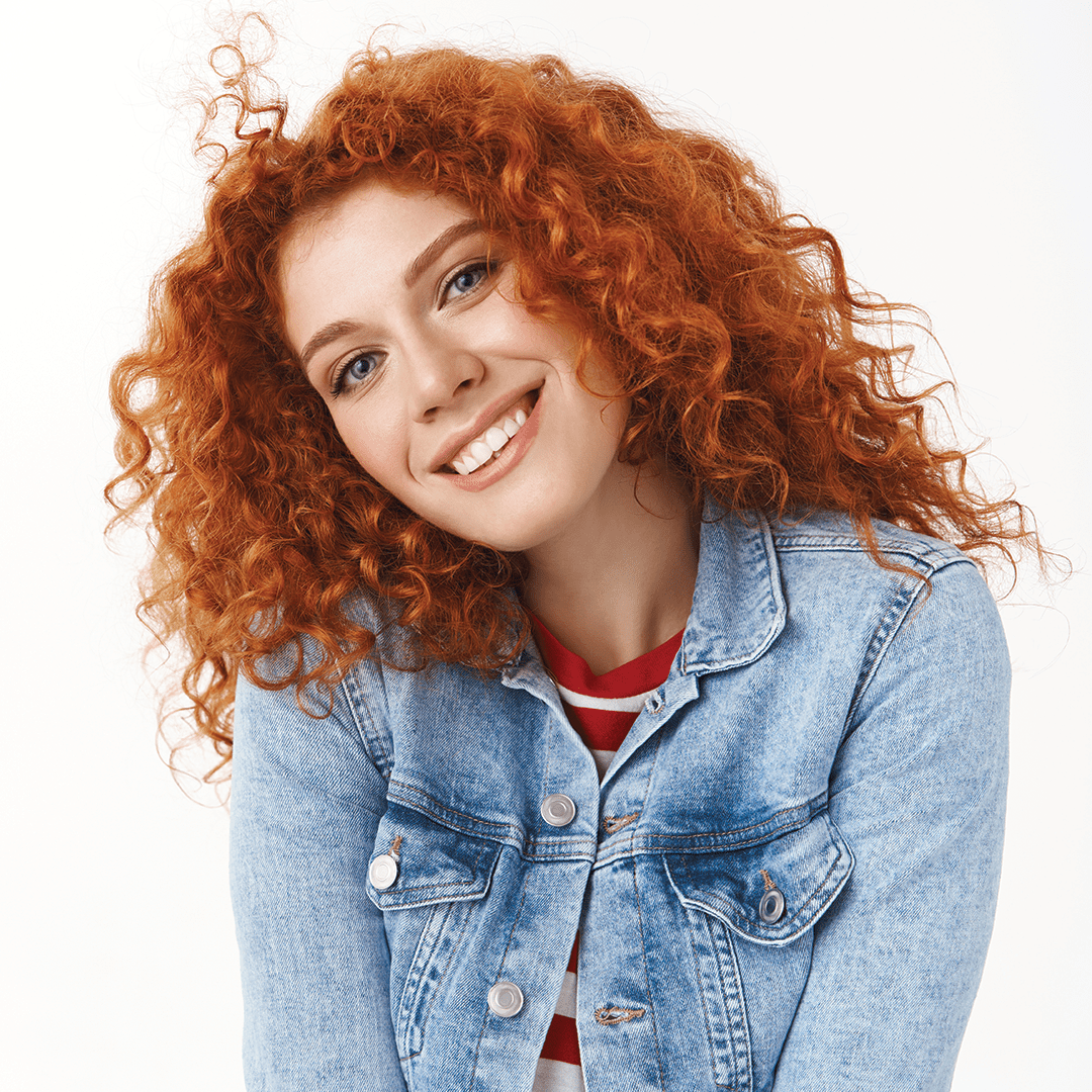 Subtle red hair color with cinnamon and strawberry blonde tones on woman with loose waves