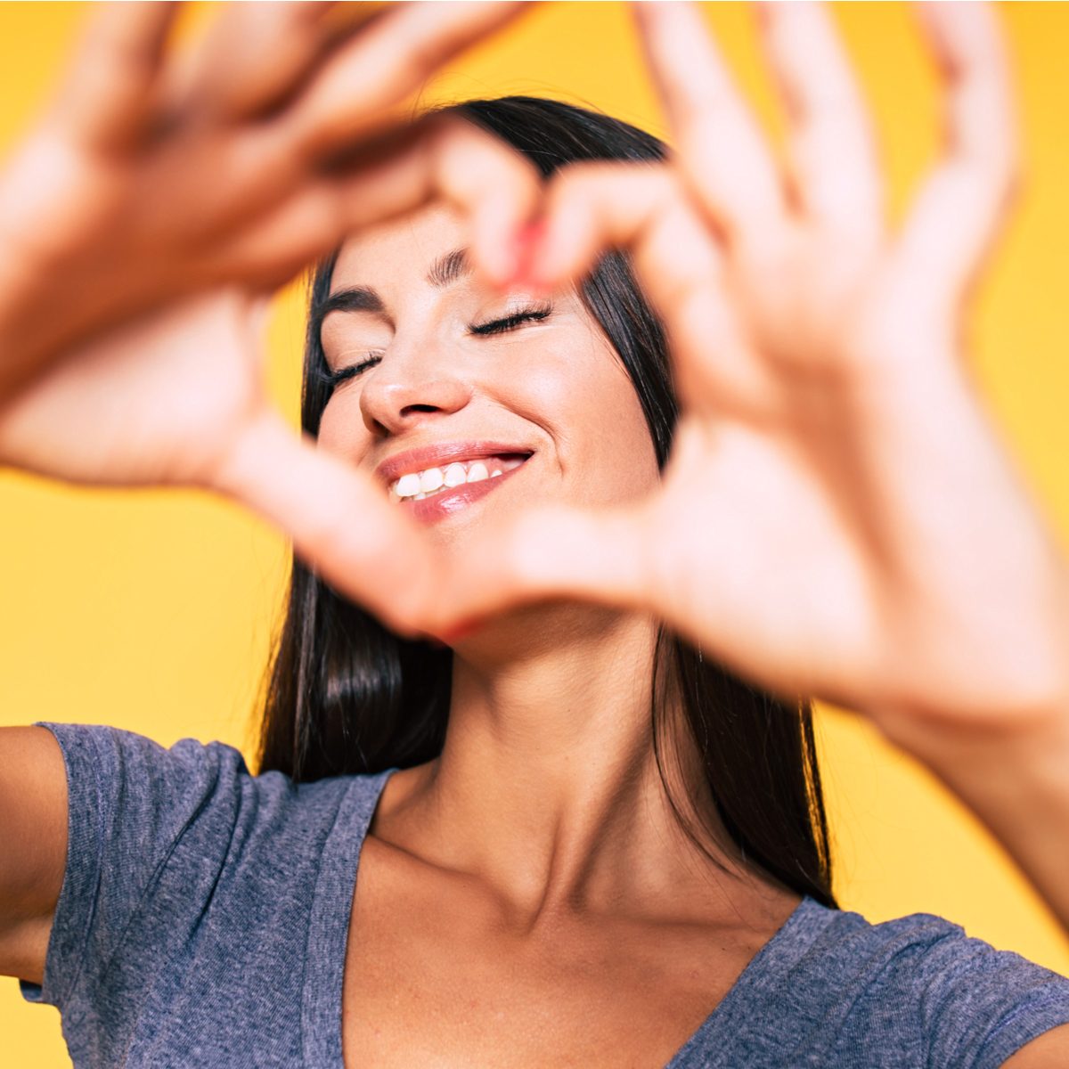 Girl creating heart shape over her face
